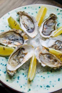 limon lu taze ve lezzetli istiridyeler bir restoranda bir tabakta yatıyor