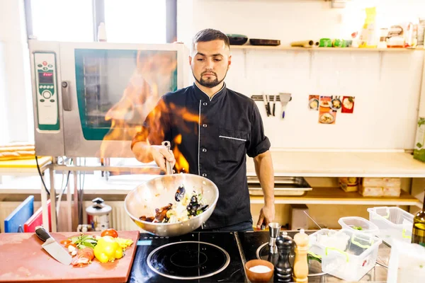 chef cooks mussels in a restaurant