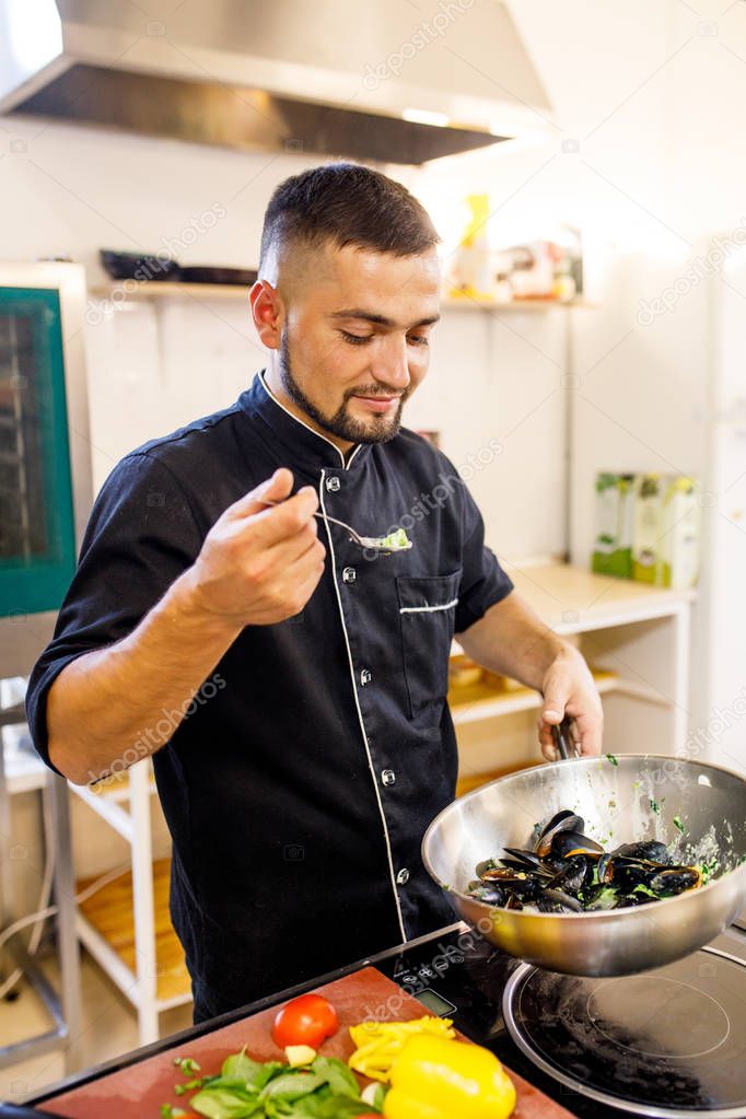 chef cooks mussels in a restaurant