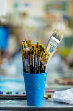 Bir atölyede boya fırçaları ve el işi malzemeleri..