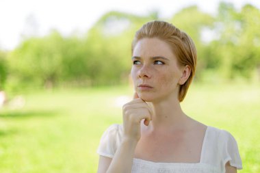 Gün batımında sıcak bir parkta güneşlenen ve dinlenen bir kadın.