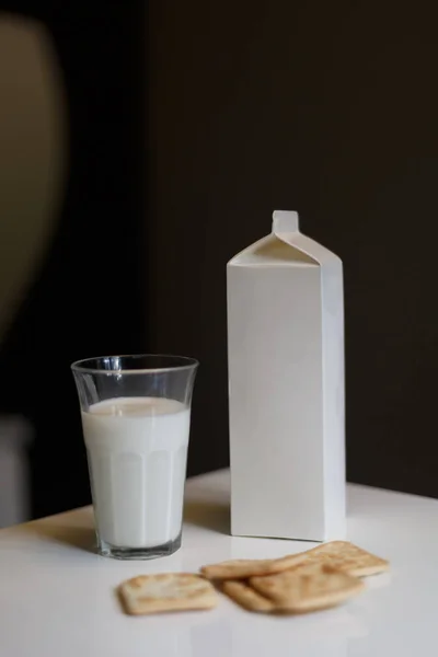 Kartonnen doos en glas melk op tafel in de keuken — Stockfoto