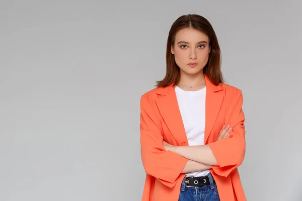 Çekici, kendine güvenen, yaratıcı, güzel görünümlü, patronluk taslayan, kollarını kavuşturan, kendine güvenen, gülümseyen, kendine güvenen, hedeflerine ulaşan, şanslı, tek renkli arka plan sahibi bir kadın.