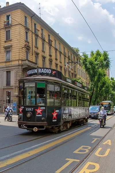 Milan, İtalya - 22 Haziran 2018: Retro siyah tramvay yolcu ile Milan sokakta. Şehrin sembolü, geleneksel Atm sınıfı 1500 1927 yılından kullanılan tramvaylar dizisidir. Geniş açılı görünüş.