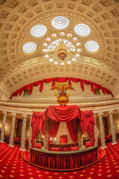 WASHINGTON DC, USA - SEPTEMBER 4, 2018: First Congress room decorated with red curtains in Capitol building. Presidential desk is ornate with Golden Eagle Spread Wings American USA Coat of Arms.