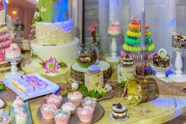 Düğün pastası ve yapay çiçeklerle dekore edilmiş ve boyalı özel tatlılar.