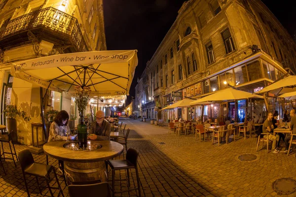 Vista nocturna de pintorescas terrazas de calle con turista, Timisoar — Foto de Stock