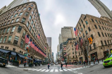 NEW YORK, ABD-Mart 7, 2020: Amerikan bayraklarıyla süslenmiş eski ticari bina, Manhattan 'da, 5. Cadde' de E 50. Cadde ile St. Patrick Katedrali ve Rockefeller Merkezi 'nin kesiştiği yerde..