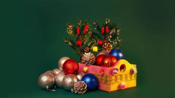 Feliz Año Nuevo y Chritsmas. Bolas y conos de plata, rojo y azul en canasta de madera con ramas de árbol de navidad verde. Juguetes de Navidad caseros y decoraciones sobre fondo verde . —  Fotos de Stock