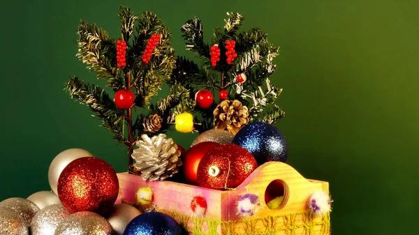 Feliz Año Nuevo y Chritsmas. Bolas y conos de plata, rojo y azul en canasta de madera con ramas de árbol de navidad verde. Juguetes de Navidad caseros y decoraciones sobre fondo verde . — Foto de Stock