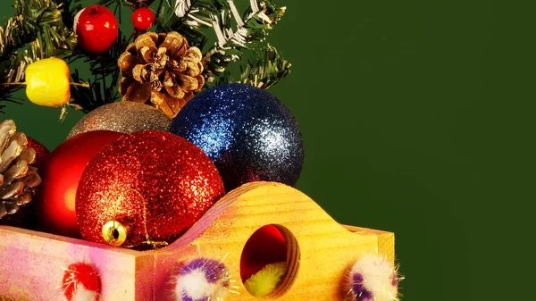 Gelukkig Nieuwjaar en Chritsmas. Zilveren, rode en blauwe ballen en kegels in houten mandje met groene kerstboomtakken. Zelfgemaakte kerst speelgoed en decoraties op groene achtergrond. Rechtenvrije Stockafbeeldingen