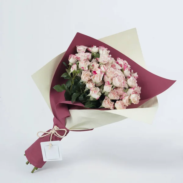 Buket pembe Gül renkli pembe ve gri bir arka plan üzerinde ambalaj beyaz güzel çiçek