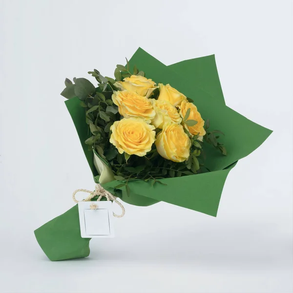 Bouquet of flowers yellow roses in green package isolated on white — Stock Photo, Image