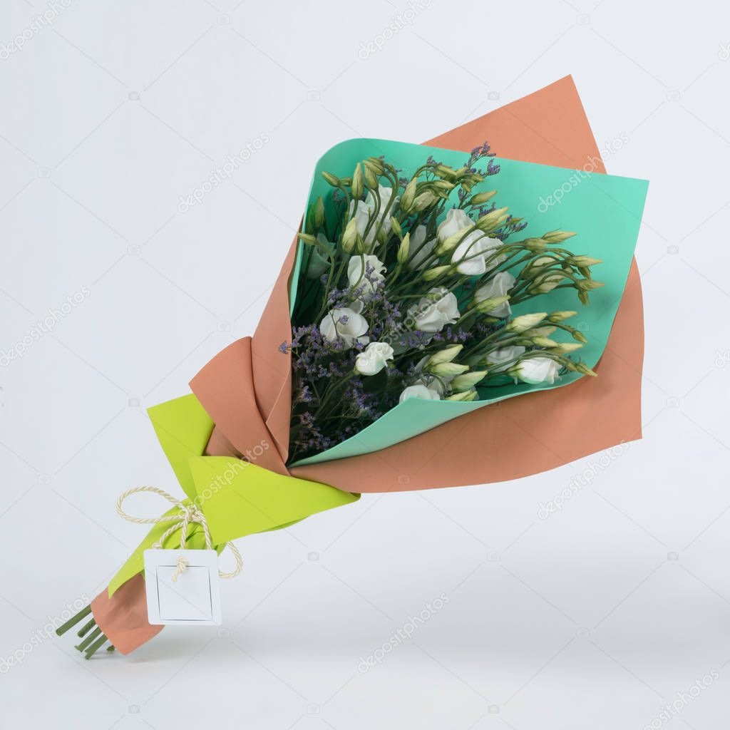 Bouquet of flowers in green and orange package isolated on white