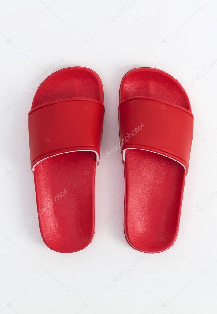 Bright red stylish rubber slippers, on a white and gray background, mock-up