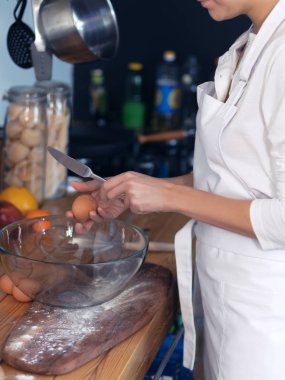 Kız cook donanımlı mutfakta aşçılar yumurta ve un beyaz bir önlük