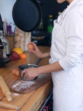 Kız cook donanımlı mutfakta aşçılar yumurta ve un beyaz bir önlük