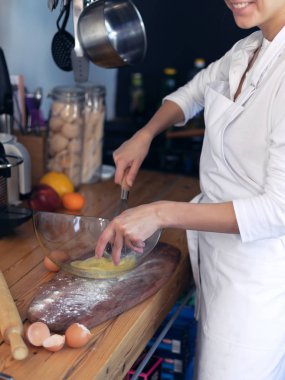 Kız cook donanımlı mutfakta aşçılar yumurta ve un beyaz bir önlük