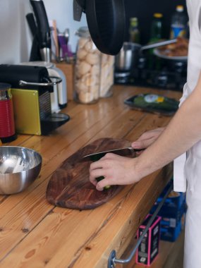 Kız yemek mutfakta, kesim ahşap kesme tahtası üzerinde beyaz bir önlük