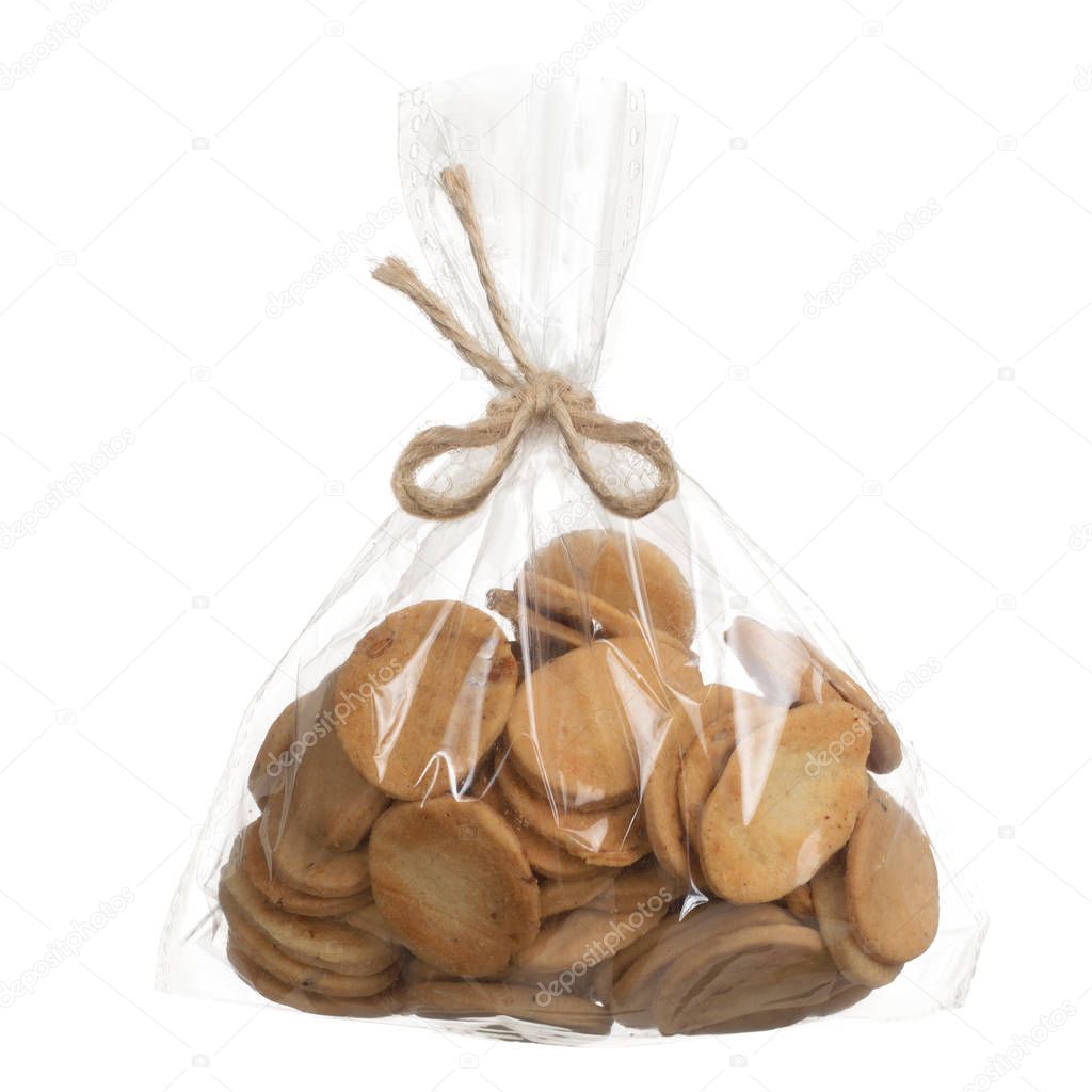 Crispy natural organic cookies in a package tied with natural craft rope, isolated on a white background