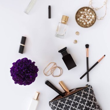 Beyaz bir zemin üzerinde kozmetik ürünler ve aksesuarlar, desen, kozmetik çanta, parfüm, küpe, çiçek ve ruj, tasarım için.