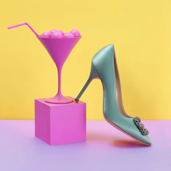 Luxurious turquoise satin with crystals a high-heeled shoe stands on a pink cube and a martini glass with pink bubbles, on a yellow background, shoe advertising, banner, mock-up