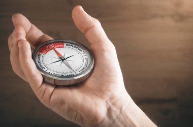 Erkek eli pusulayı iğneyle en iyi fırsatı gösteren metni gösteriyor. İş veya kariyer fırsatlarını resmetmek için resmi kavra.