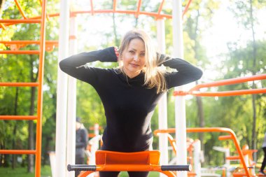 Yaz sporları sahasındaki kız arka tarafta spor egzersizleri yapıyor. Atletik alan