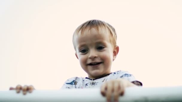 De kleine jongen trekt op de balk — Stockvideo