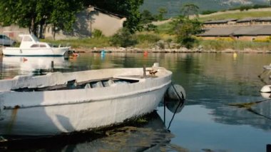 Eski paslı balıkçı teknesi iskeleye demirli duruyor.