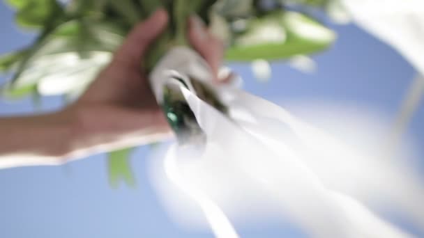 Vacker brudbukett i händerna på unga bruden klädd i vit brudklänning. Närbild av stora gäng färska vita rosor och tulpaner blommor i kvinnliga händer. Anonym brud holding blommor. — Stockvideo