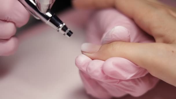 Master makes manicure with airbrush in white — Stock Video