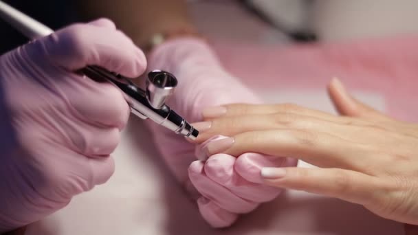 Master makes manicure with airbrush in white — Stock Video