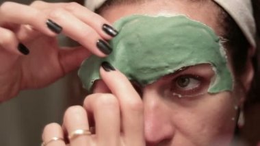 Yüz maskesi ile güzel bir kadın. Genç kadın yüz maskesi alma Spa terapisi.