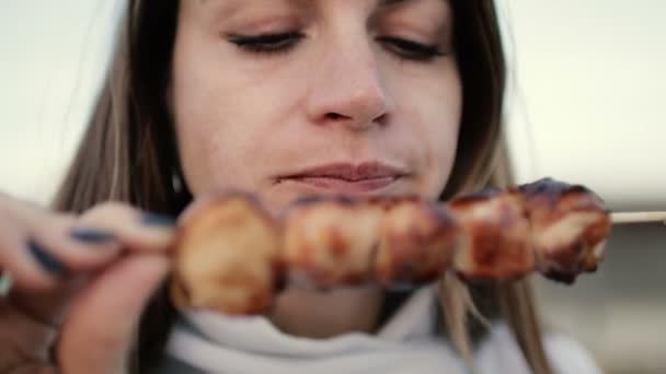 Schöne Frau beißt riesige Fleischstücke essen mit wütenden Händen unangemessen in Großaufnahme — Stockvideo