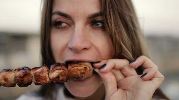 Bella donna mordere enormi pezzi di carne mangiare con le mani arrabbiato inappropriato in primo piano vista — Video Stock