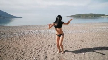Siyah bikini Mayo ile bir güzel spor artistik danslar sahil üzerinde seksi kız