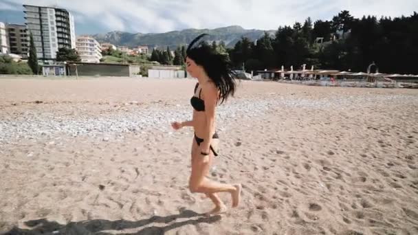 Kobieta z idealne dopasowanie do ciała biegać pewny siebie na plaży. Nie do poznania seksowna młoda kobieta. Szeroki kąt — Wideo stockowe