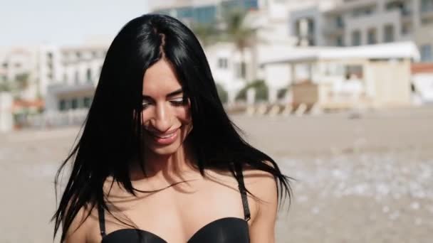 Девушка с сексуальной фигурой прогуливается по пляжу — стоковое видео
