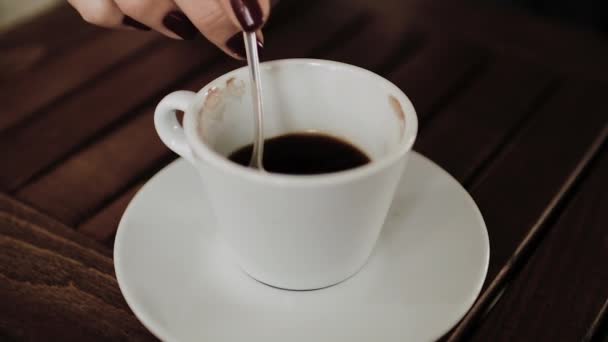一杯のコーヒーをクローズ アップ 女性手コーヒーのスプーンでかき混ぜる — ストック動画
