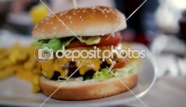 Büyük bir pirzola ve patates kızartması ketçap ile bir kavanoz ile lezzetli hamburger. Yakın çekim 60fps