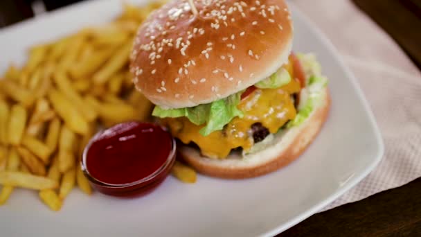 Delicious hamburger with a big chop and a jar of french fries with ketchup. Close-up 60fps