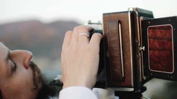 Fotograf anpassar storformatskamera före fotografering — Stockvideo