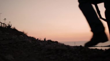 Gün batımında çerçeveden bir tripod ile fotoğrafçı