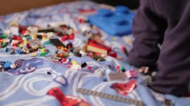 Yatakta çocuk tasarımcısı oynayan bir çocuk