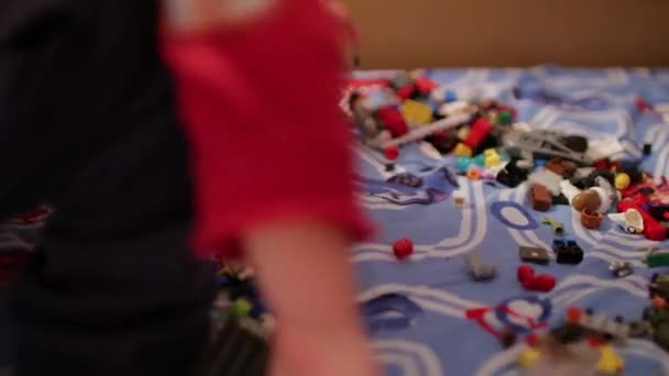 Ein Kind spielt in der Kinderdesignerin auf dem Bett — Stockvideo
