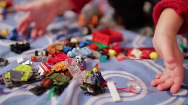 Un niño jugando en el diseñador de niños en la cama — Vídeo de stock