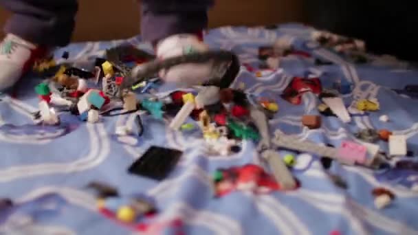 Ребенок играет в детском дизайнере на кровати — стоковое видео