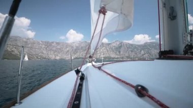 Rüzgar yelken içine patlar. Yelken farklı yönlere atar.