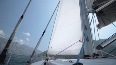 Rüzgar yelken içine patlar. Yelken farklı yönlere atar.